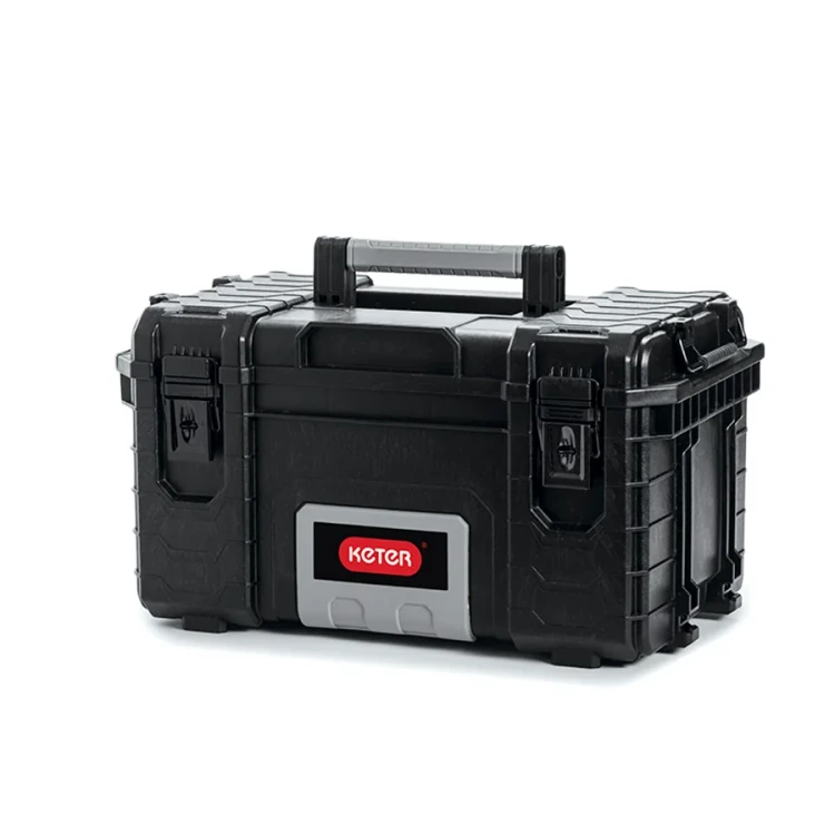 Prostokątna skrzynka narzędziowa z czarnego tworzywa sztucznego z szarym panelem i czerwonym logo na przedzie, zamykana na dwa klipsy i z uchwytem na górze; widok z przodu.