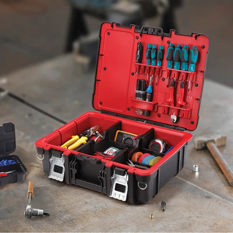 Walizka narzędziowa otwarta na blacie roboczym, wypełniona narzędziami, w tle rozrzucone śruby i młotek.