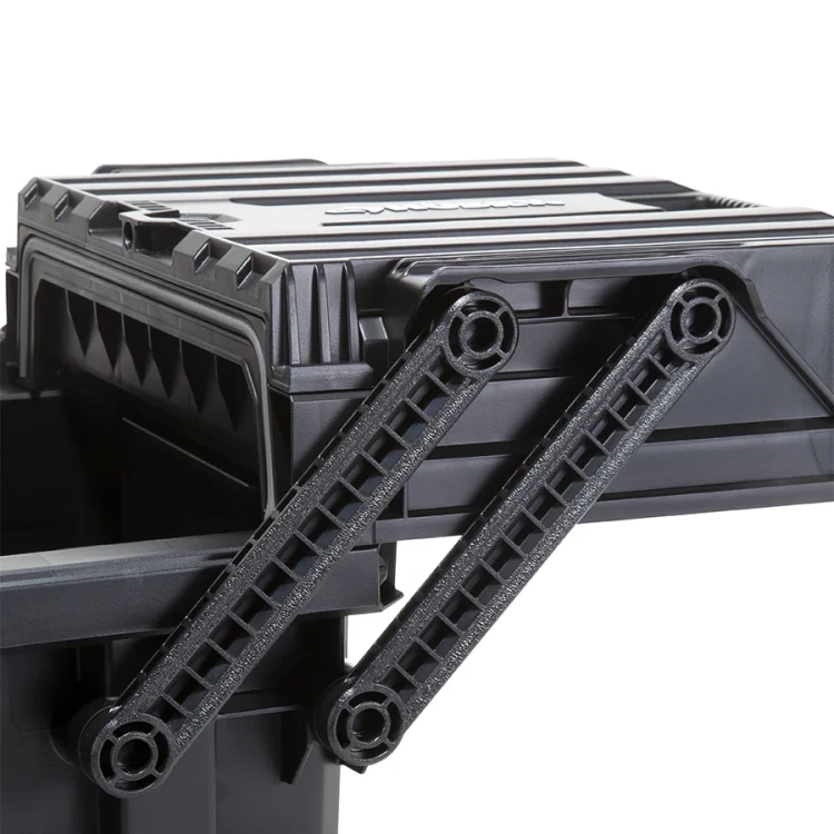 Zbliżenie na mechanizm unoszenia pokrywy z podwójnym, ruchomym ramieniem o zębatym profilu, wykonanym z czarnego tworzywa.