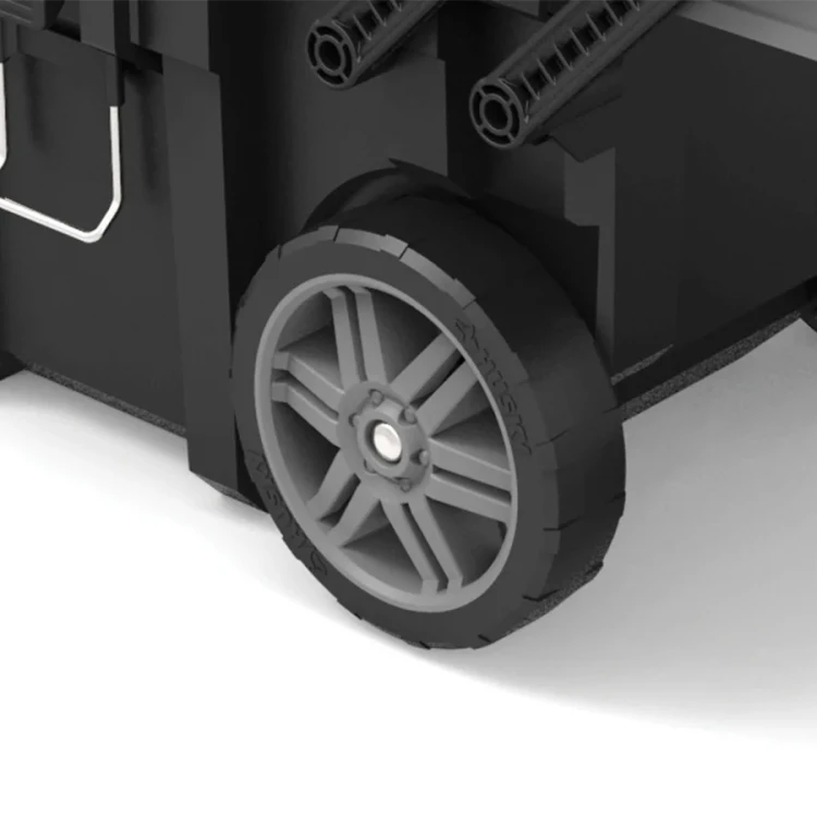 Zbliżenie na koło skrzynki – ciemnoszara, szeroka opona z plastikowym, wieloramiennym środkiem.