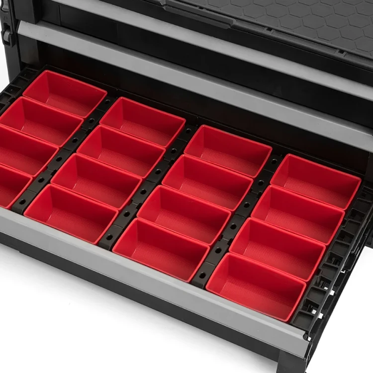 Zbliżenie na szufladę z czerwonymi pojemnikami ułożonymi w równych rzędach, widok z góry.